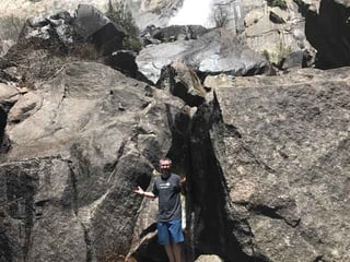 Brian standing near a rock structure.